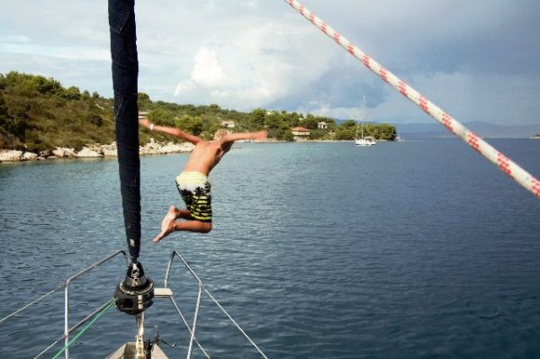 Ein Mann springt vom Boot ins Meer