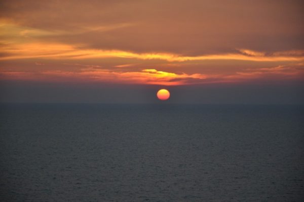 Man sieht ein Sonnenuntergang über dem Meer